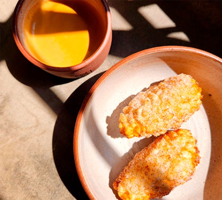 Bolinhos de milho fritos servidos com café na caneca de barro