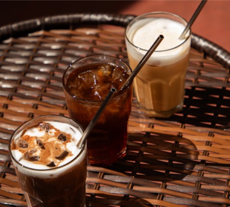 Cafés gelados com leite e canudos de metal na mesa