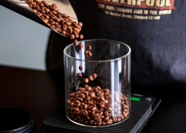 Grãos de café dosados em copo de vidro reutilizável