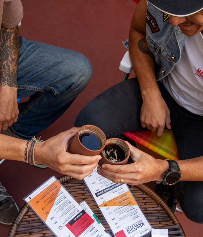 Clientes brindando com canecas de barro sobre o cardápio