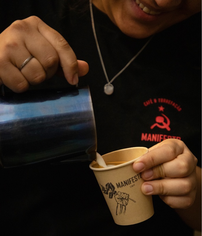 Barista do Manifesto passando leite na xícara