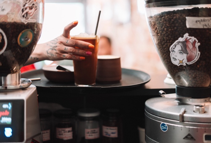 Moedores de café no balcão com café gelado